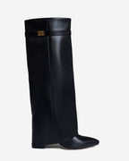Women's black knee-high boots with pointed toes and buckle strap