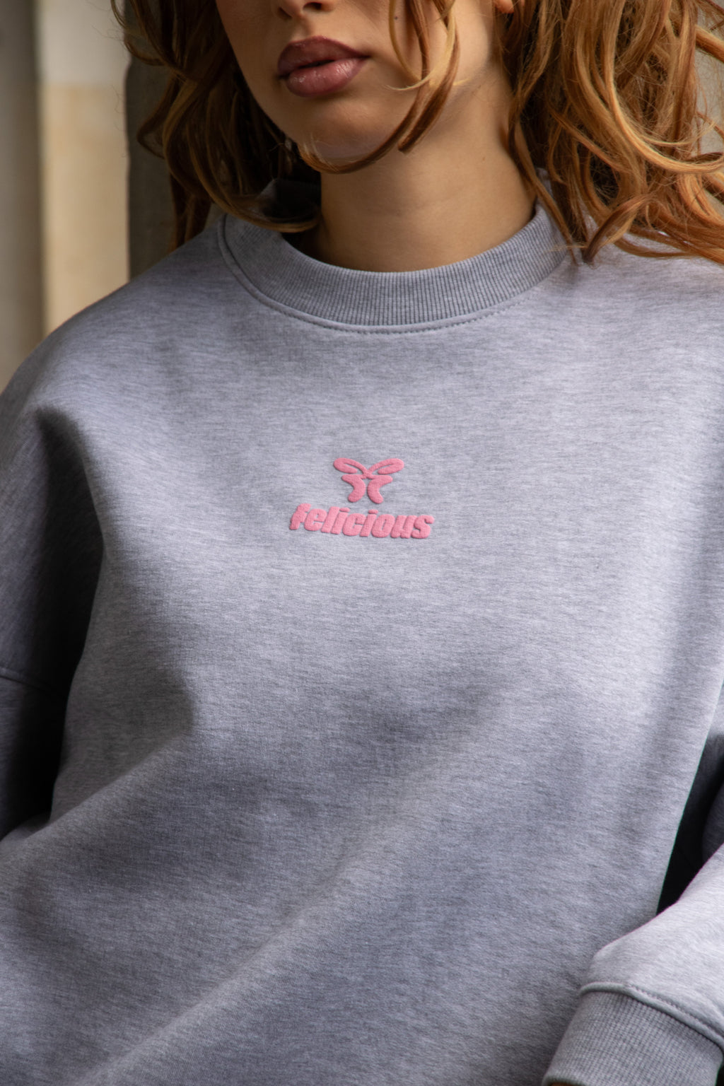 Women's light grey crewneck sweatshirt with pink chest logo