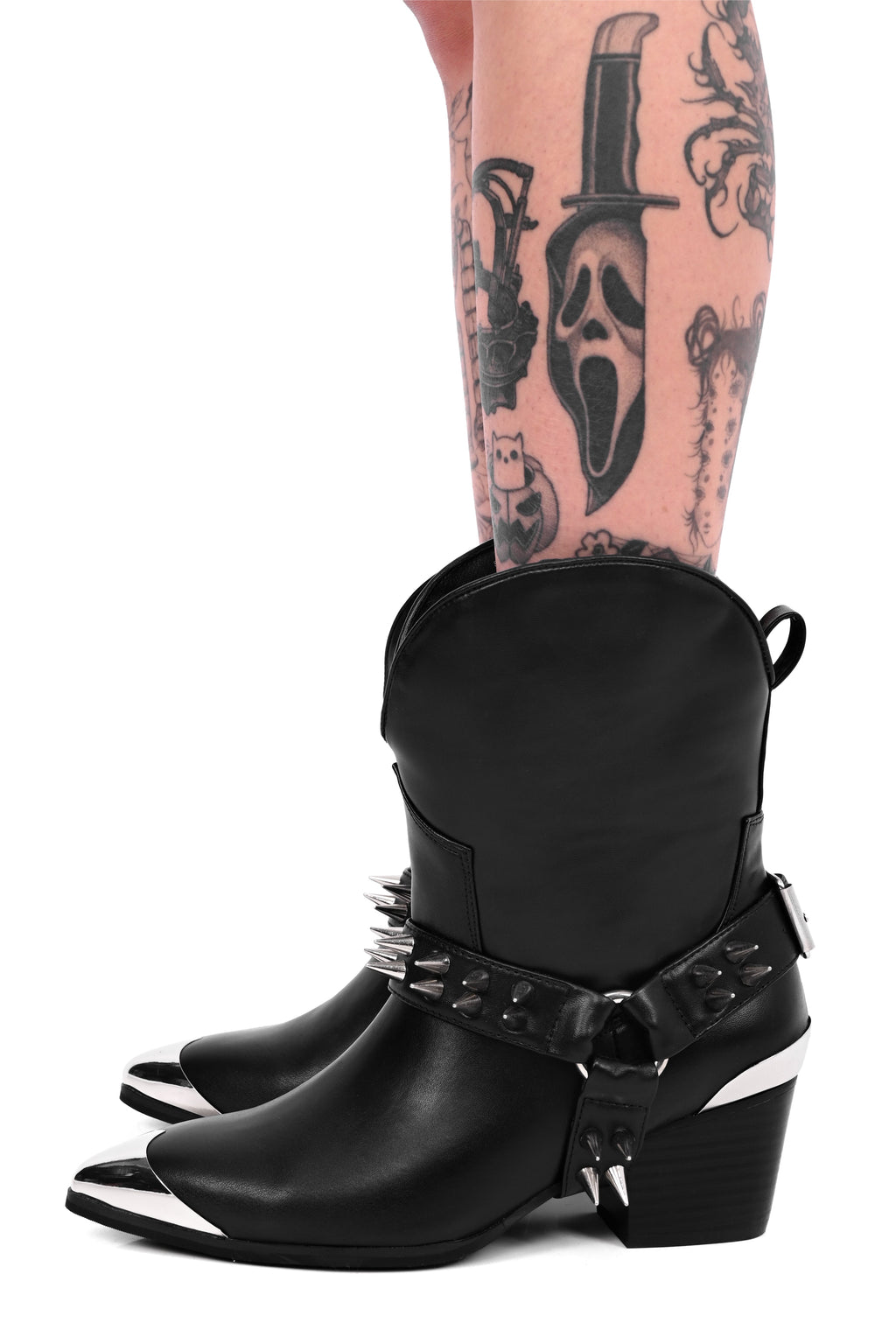 Women's black cowboy boots with silver toe caps and spiked straps
