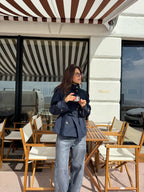 Women's navy short belted jacket with high collar, buttons and flap pockets