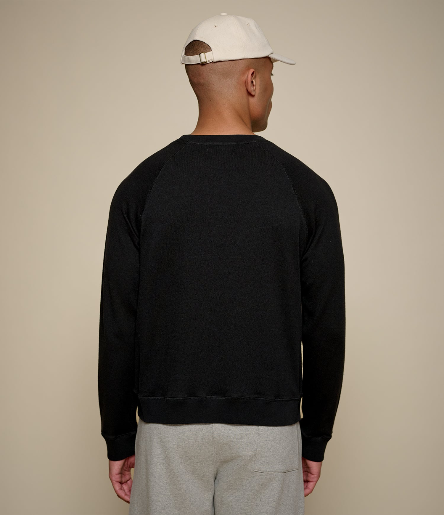 Men's black raglan crew neck sweatshirt with ribbed hem