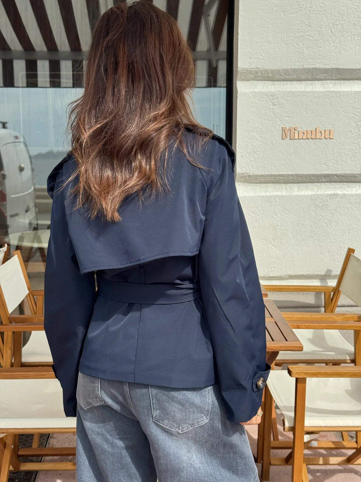 Women's navy short belted jacket with high collar, buttons and flap pockets