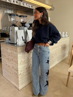 Women's light blue wide leg jeans with studded star leg details