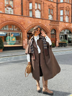 Women's brown long trench coat with wide lapels and cape-style sleeves