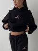 Women's black cropped hoodie with pink chest logo
