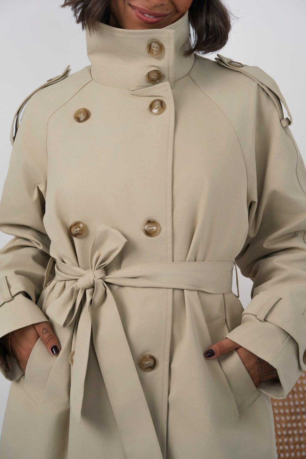 Women's beige long trench coat with high collar, buttons and tied waist belt