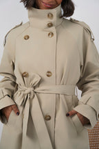 Women's beige long trench coat with high collar, buttons and tied waist belt