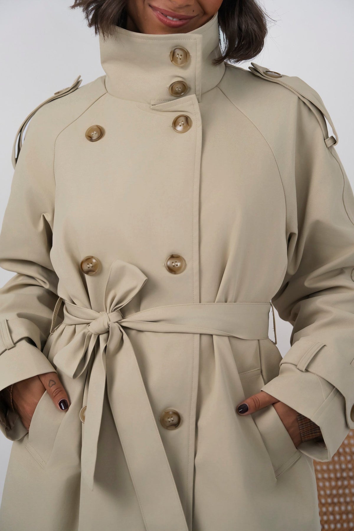 Women's beige long trench coat with high collar, buttons and tied waist belt