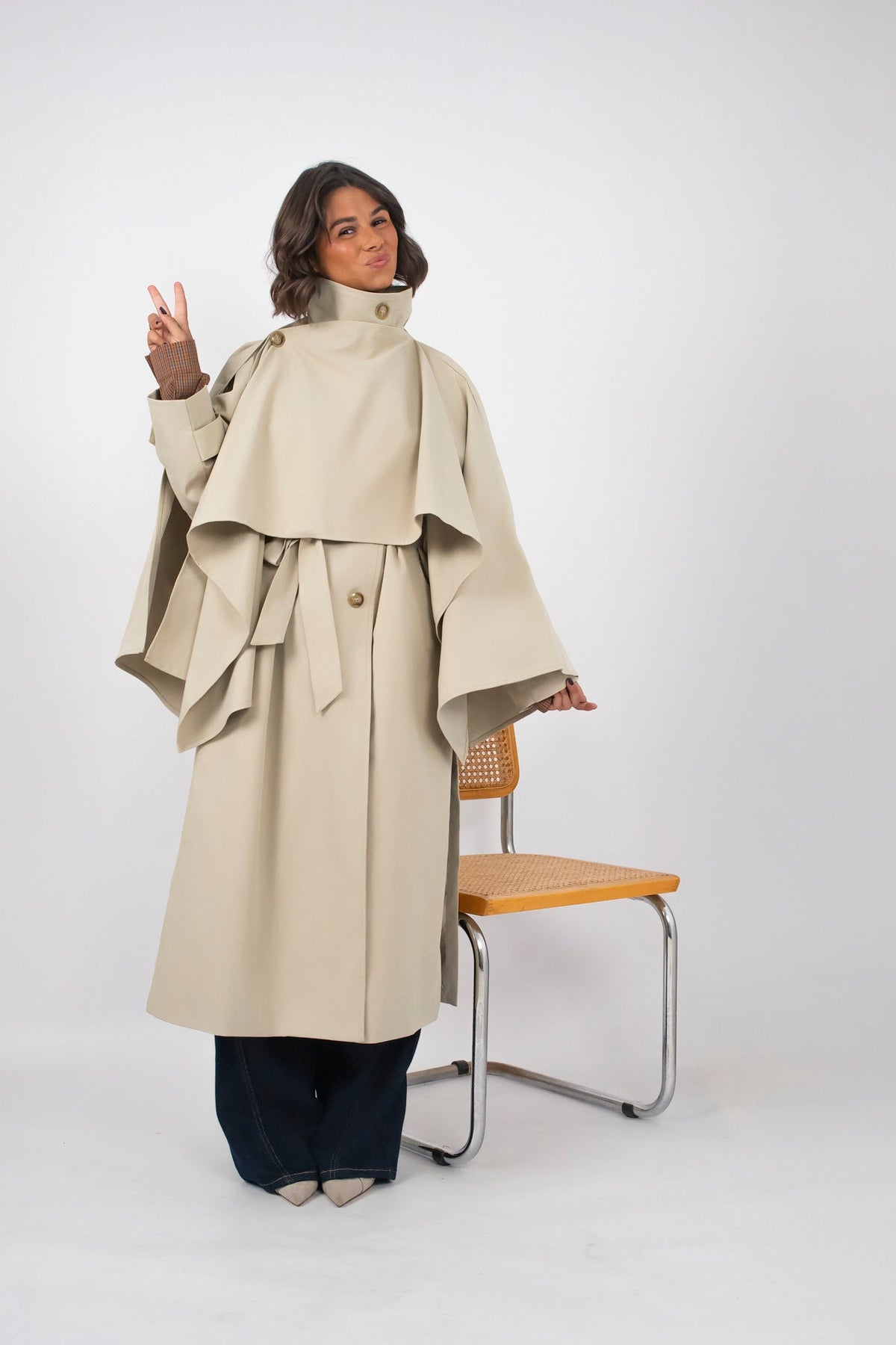 Women's beige long trench coat with high collar, buttons and tied waist belt