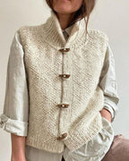 Cream sleeveless knitted cardigan with funnel neck and toggle fastenings