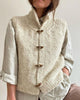 Cream sleeveless knitted cardigan with funnel neck and toggle fastenings
