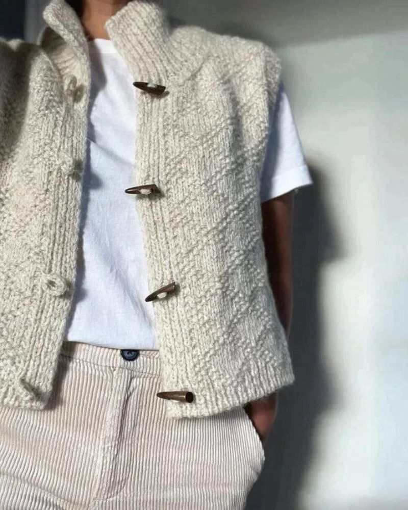 Cream sleeveless knitted cardigan with funnel neck and toggle fastenings