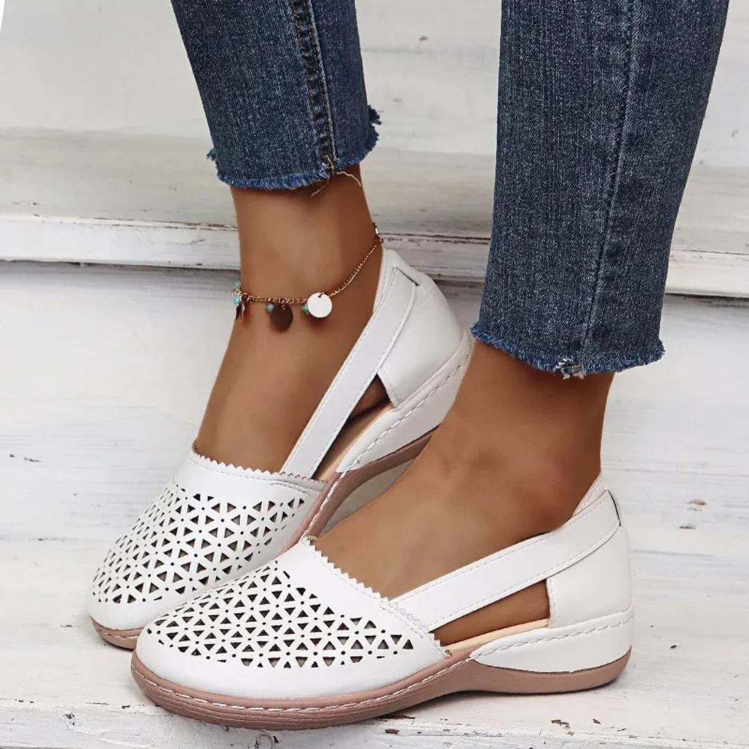 Women's perforated Mary Jane flats with triangular cutouts and an instep strap