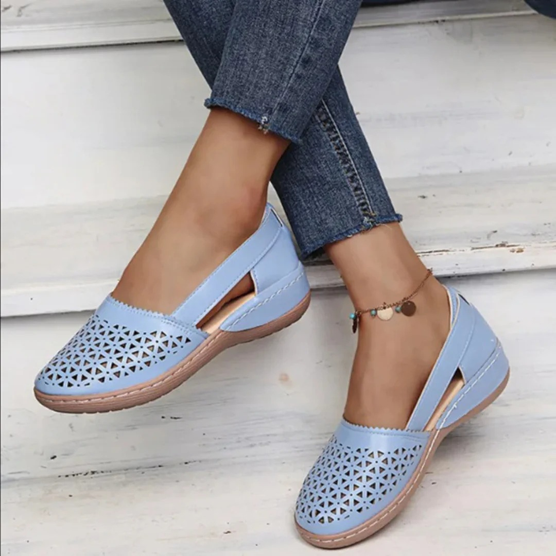 Women's perforated Mary Jane flats with triangular cutouts and an instep strap