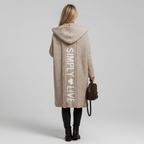 Woman wearing a longline hooded cardigan with vertical text and heart detail