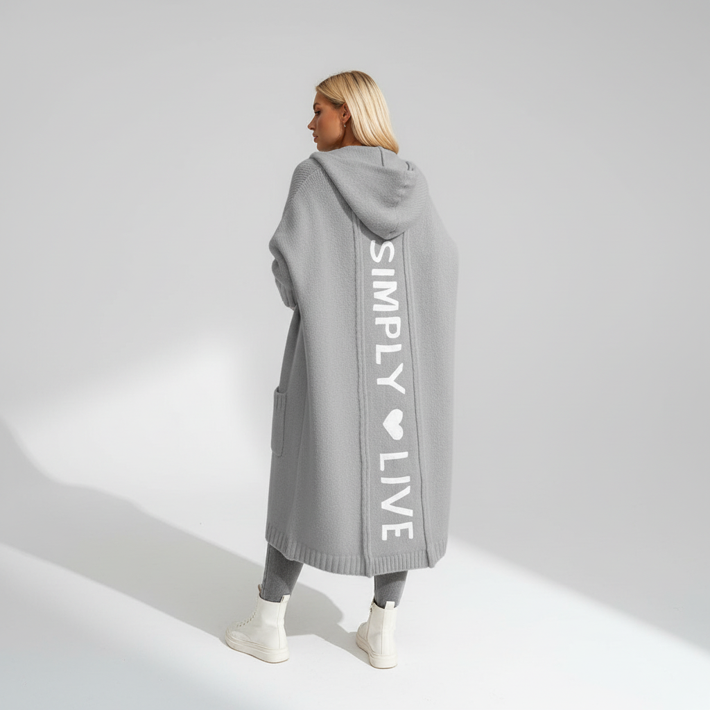 Woman wearing a longline hooded cardigan with vertical text and heart detail
