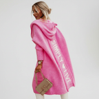 Woman wearing a longline hooded cardigan with vertical text and heart detail