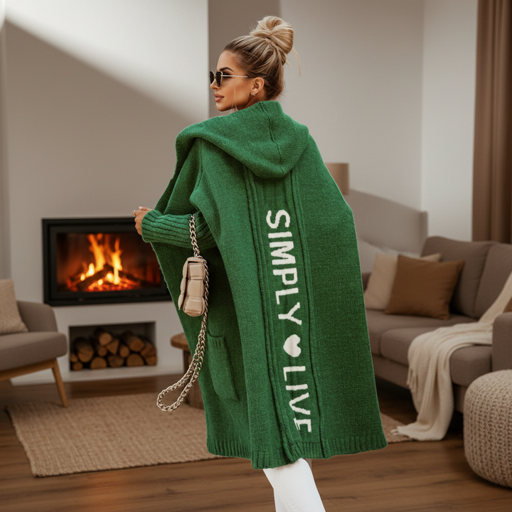 Woman wearing a longline hooded cardigan with vertical text and heart detail
