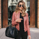 Woman wearing a fitted leather jacket with stand collar and zipper
