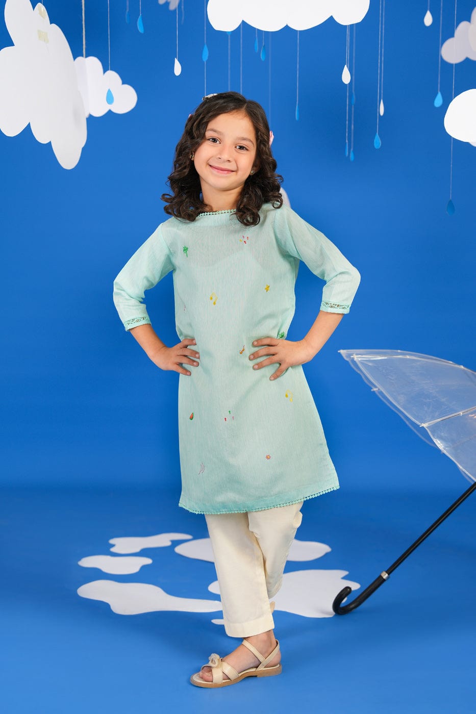 Girl wearing a green long-sleeve tunic shirt with small colourful embroidered motifs