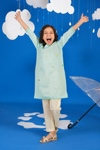 Girl wearing a green long-sleeve tunic shirt with small colourful embroidered motifs