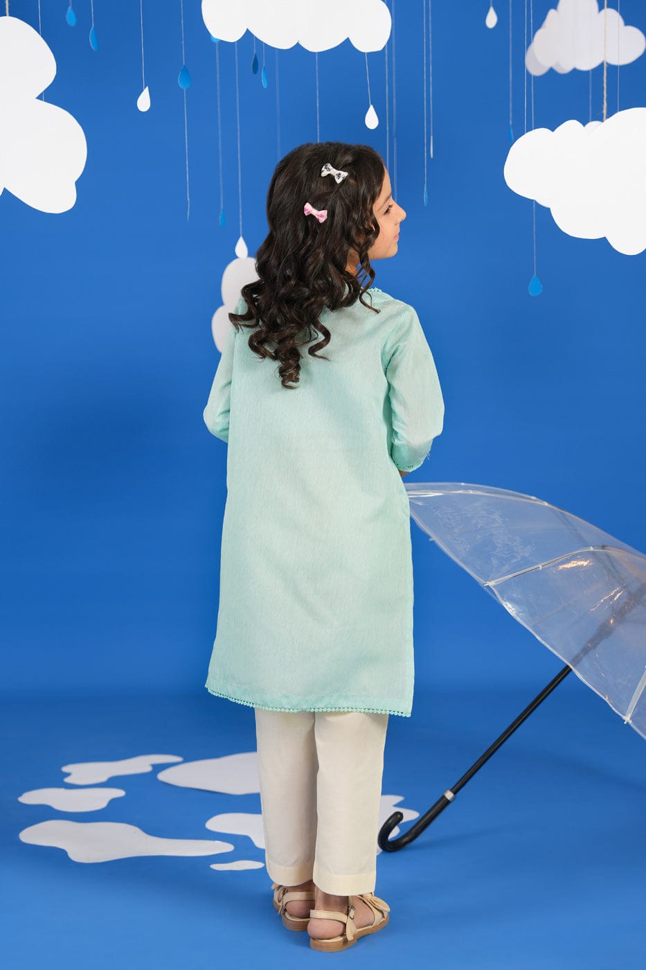 Girl wearing a green long-sleeve tunic shirt with small colourful embroidered motifs
