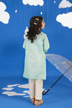 Girl wearing a green long-sleeve tunic shirt with small colourful embroidered motifs