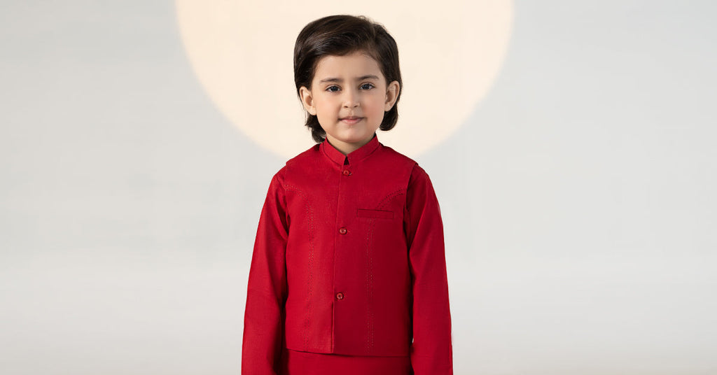Child wearing a red traditional kurta suit set with matching trousers