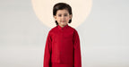 Child wearing a red traditional kurta suit set with matching trousers