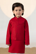 Child wearing a red traditional kurta suit set with matching trousers