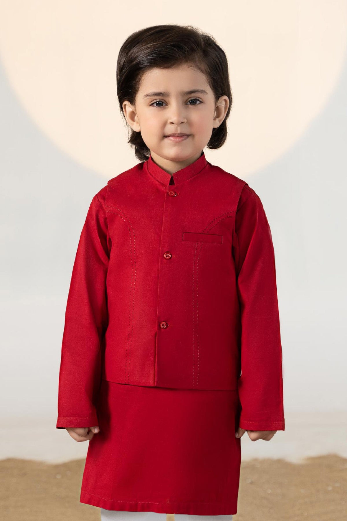 Child wearing a red traditional kurta suit set with matching trousers