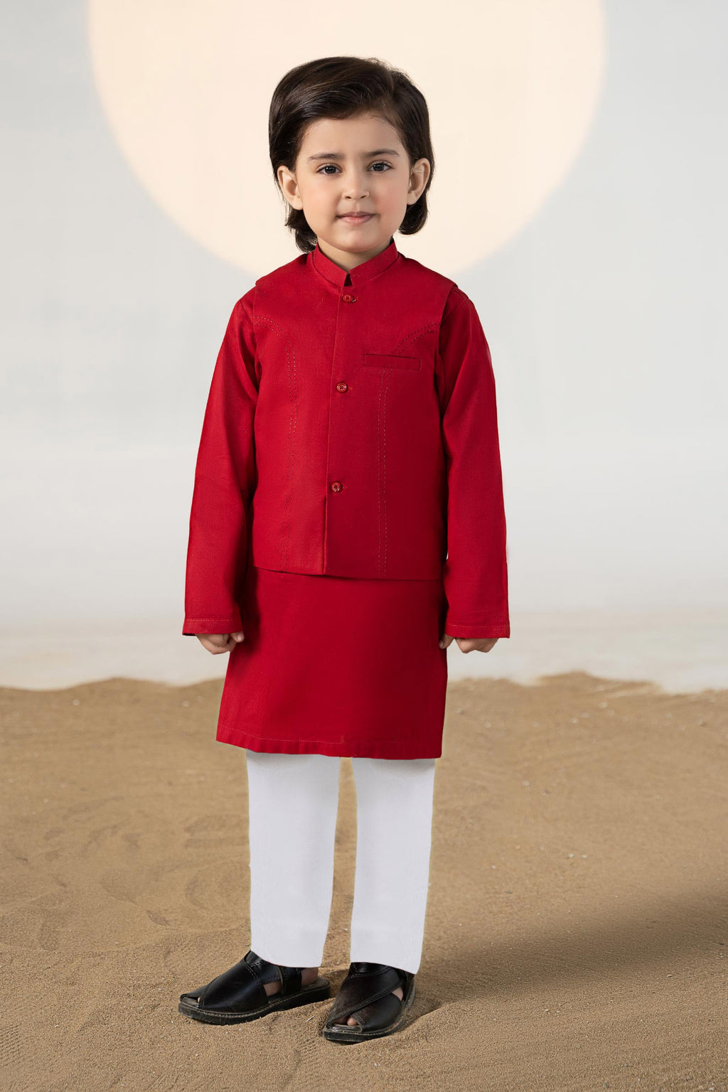 Child wearing a red traditional kurta suit set with matching trousers