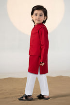 Child wearing a red traditional kurta suit set with matching trousers
