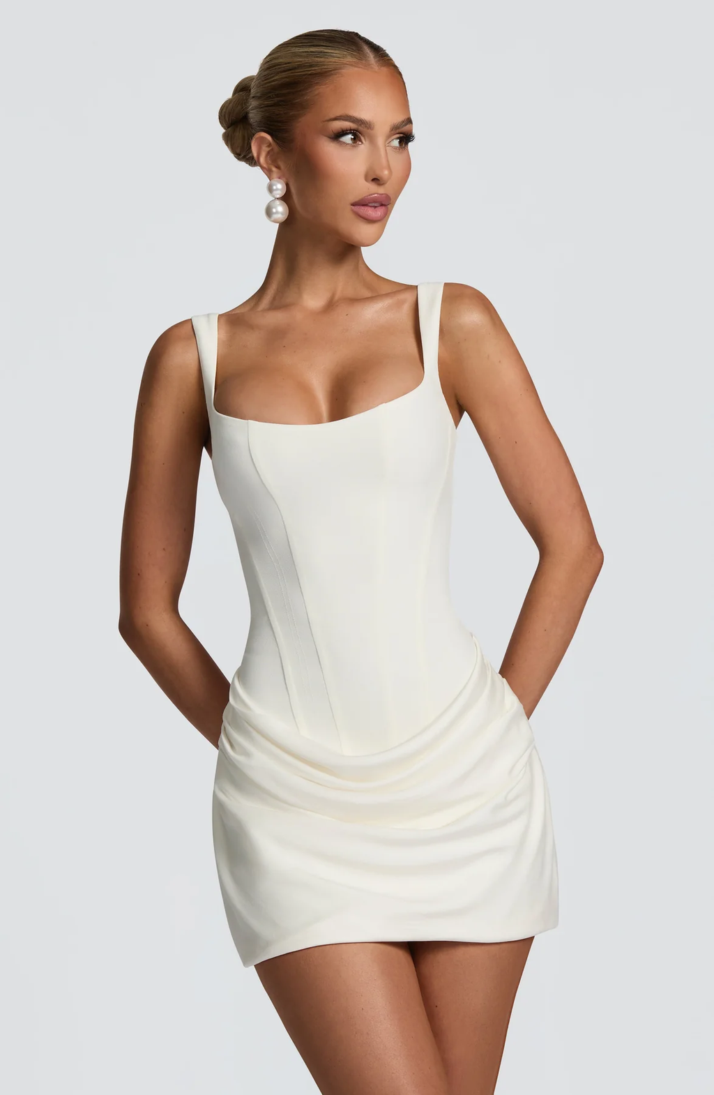 Women's sleeveless square-neck mini dress with a fitted bodice and draped ruched skirt