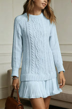 Women's long-sleeve cable knit sweater with a crew neckline and ribbed trims