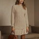Women's long-sleeve cable knit sweater with a crew neckline and ribbed trims