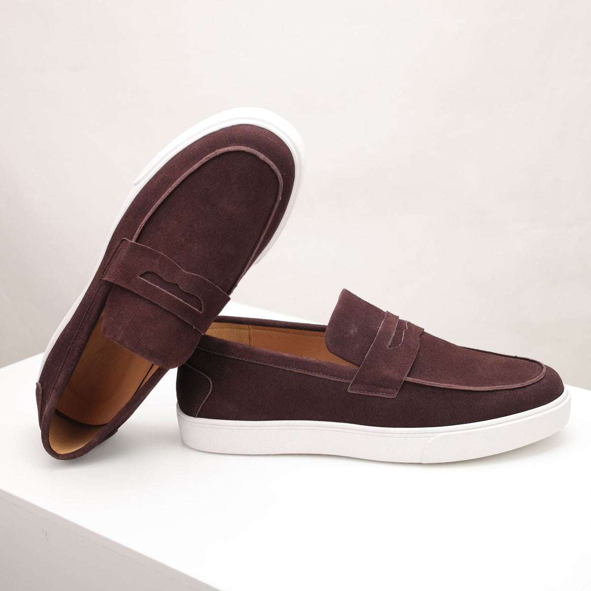 Men's penny loafers with moc toes, strap detail and white flat soles