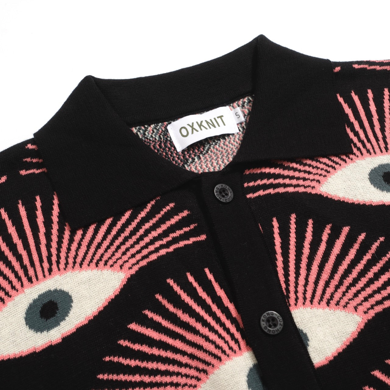 Men's black knitted polo shirt with repeated pink, cream and grey eye pattern