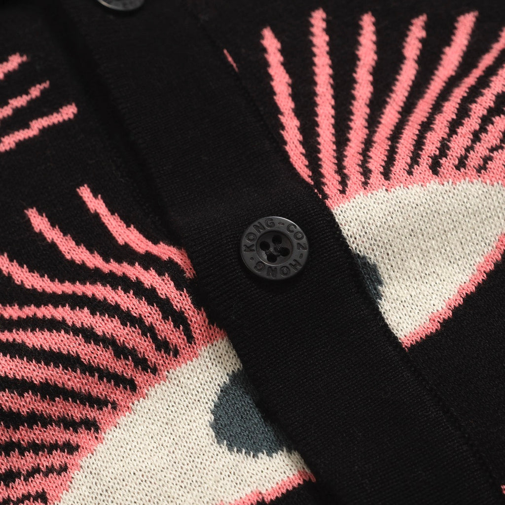 Men's black knitted polo shirt with repeated pink, cream and grey eye pattern