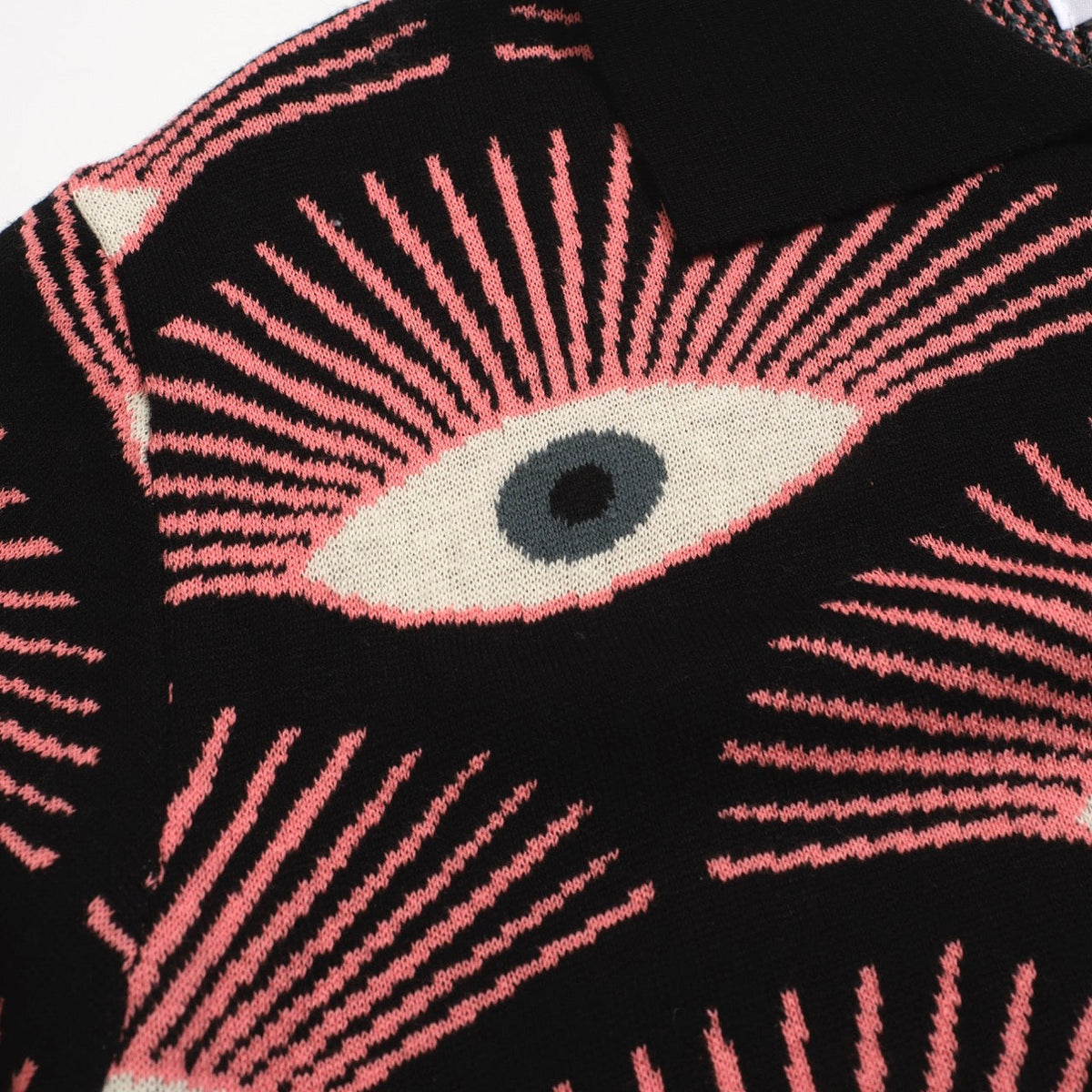 Men's black knitted polo shirt with repeated pink, cream and grey eye pattern