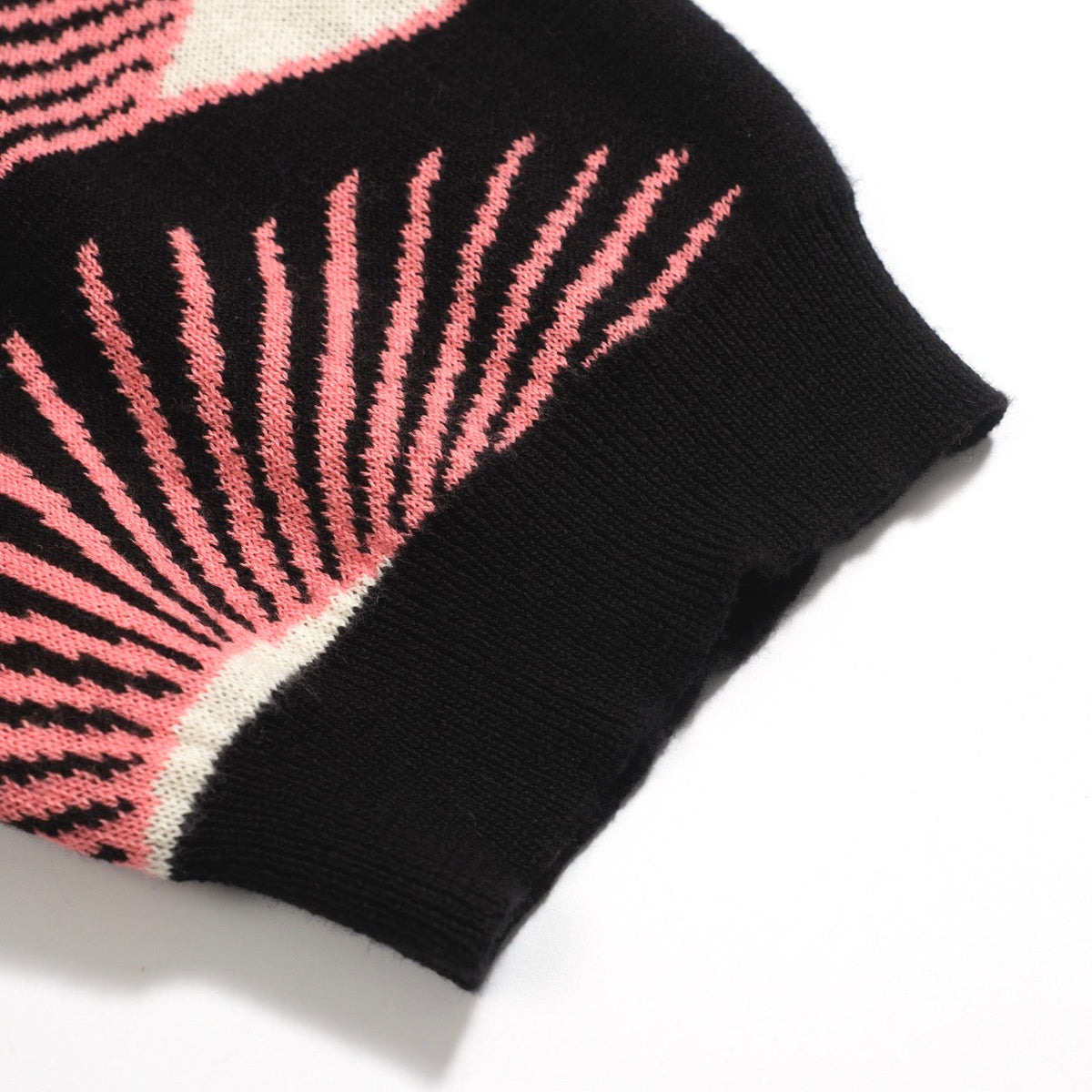 Men's black knitted polo shirt with repeated pink, cream and grey eye pattern