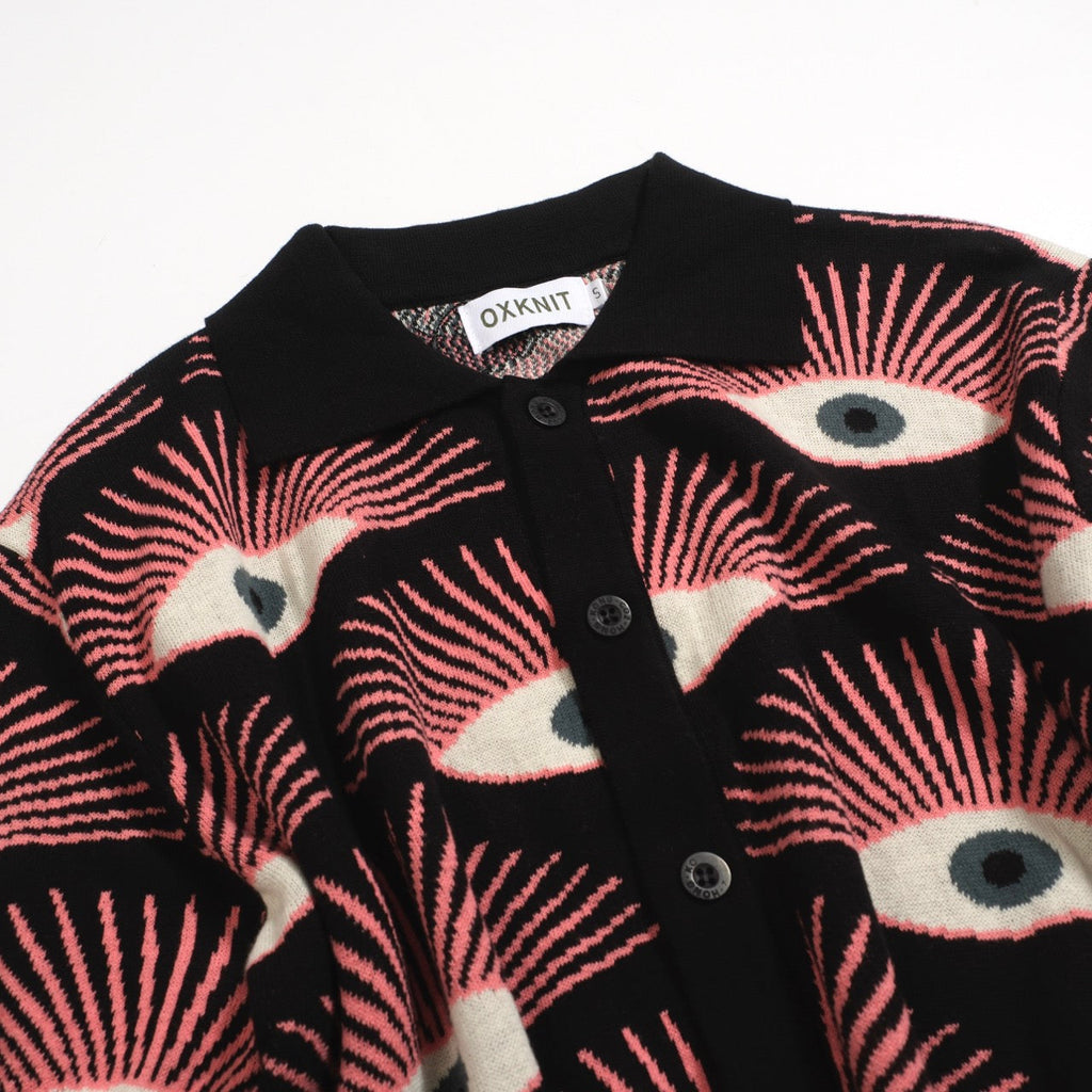 Men's black knitted polo shirt with repeated pink, cream and grey eye pattern
