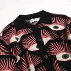 Men's black knitted polo shirt with repeated pink, cream and grey eye pattern