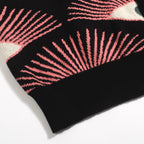 Men's black knitted polo shirt with repeated pink, cream and grey eye pattern