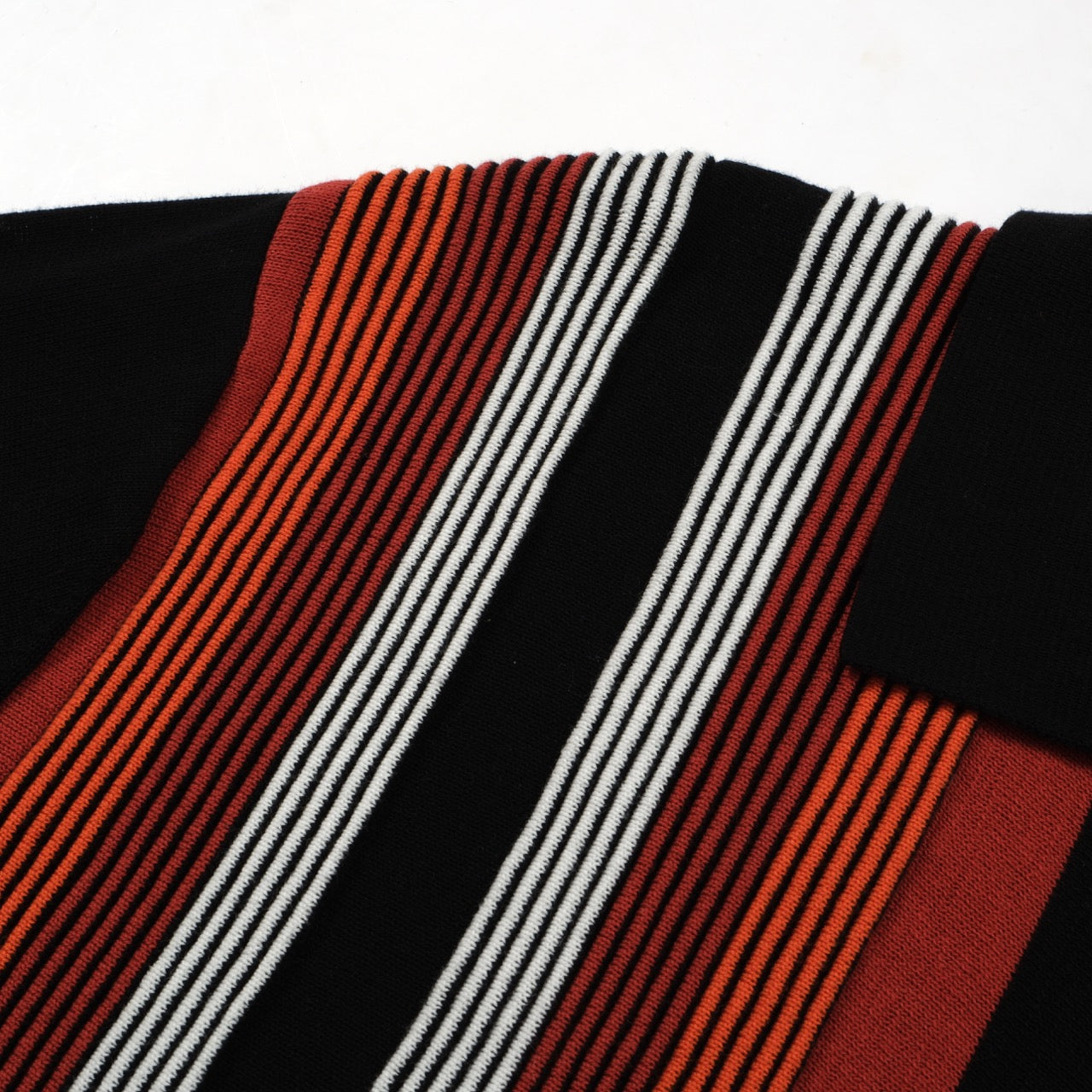 Men's black knit polo with red, orange and white vertical stripes