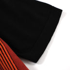 Men's black knit polo with red, orange and white vertical stripes