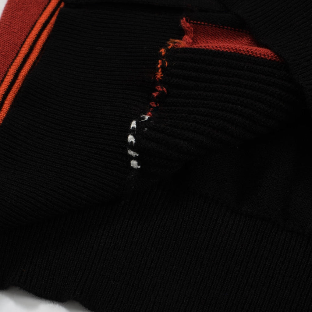 Men's black knit polo with red, orange and white vertical stripes