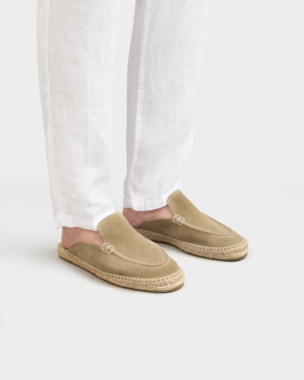 Beige unisex loafer mules with rounded toes, open heels and flat woven-effect soles
