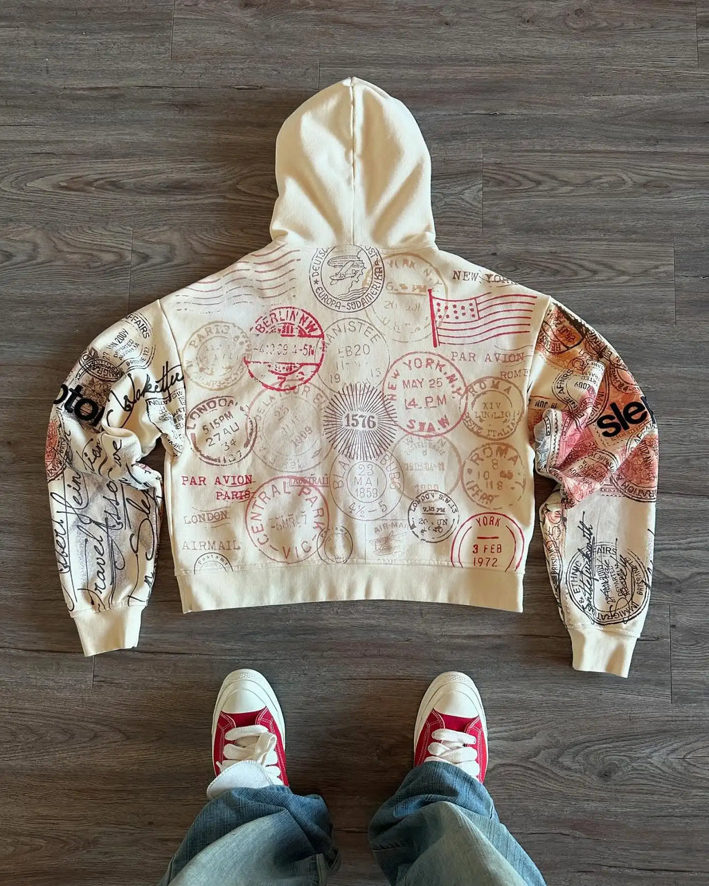 Beige hooded zip hoodie with postal stamp graphics and long sleeves