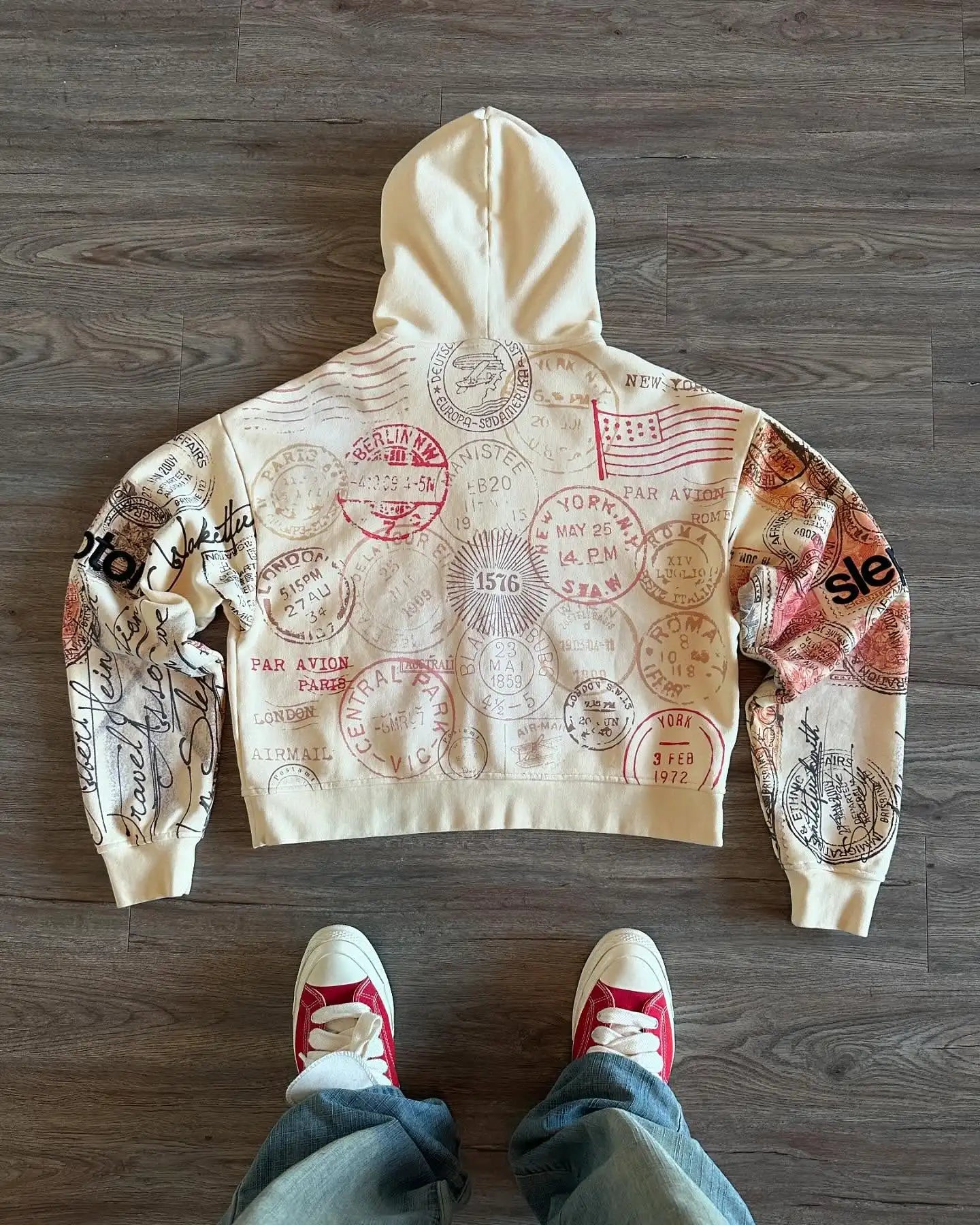 Beige hooded zip hoodie with postal stamp graphics and long sleeves